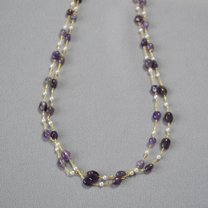 Detail of double-layer long necklace with natural purple stones and white pearls
