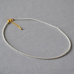 Detailaufnahme der minimalistischen Perlenkette mit goldenem Karabinerverschluss