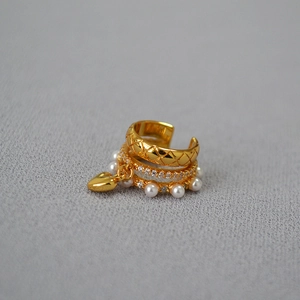 Close-up of triple-layered ear cuff with quilted gold, zircon stones, and heart pearl