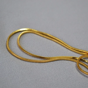 Détail d'une chaîne serpent dorée élégante montrant sa texture métallique souple