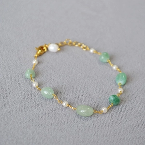 Detailed shot of green stone and white pearl beaded necklace with adjustable gold chain clasp