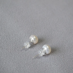 Macro shot of 925 sterling silver freshwater pearl earrings with clear silicone backs