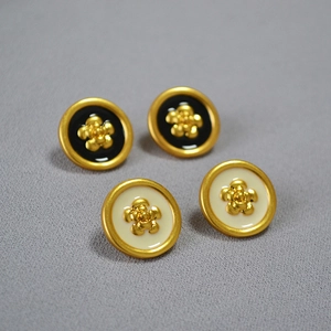 Detailed close-up of handmade enamel camellia earrings with retro gold-plated finish
