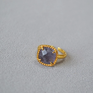 Macro shot of square purple fluorite gemstone with twisted gold rope border detail