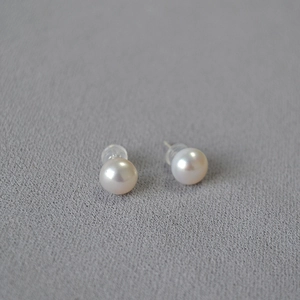 Detailed close-up of 925 sterling silver earrings with round white freshwater pearls
