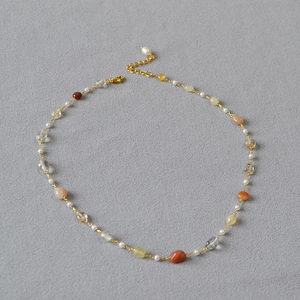 Minimalist necklace with purple and green stones, imitation pearls, and gold clasp chain