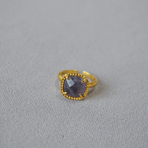 Macro shot of square purple gemstone ring with gold beaded border and adjustable open band