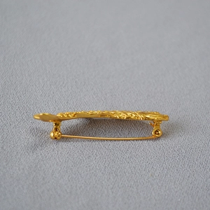 Side view of golden koi fish brooch showing intricate textures and pin mechanism