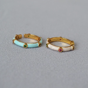 Detailed close-up of bamboo-shaped enamel rings with colorful cubic zirconia and gold plating