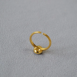 Close-up of a minimalist gold spherical open ring with high-polished mirror finish