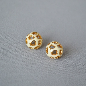 Détail macro de boucles d'oreilles sphériques ajourées avec motif léopard doré