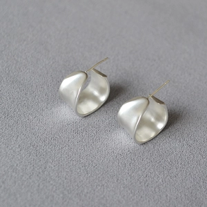 Detail shot of matte silver irregular organic earrings with brushed metal texture