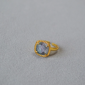 Detail of vintage gold ring with faceted fluorite stone and textured braided border