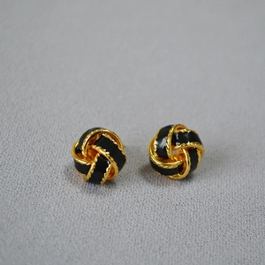 Boucles d'oreilles vintage émaillées plaquées or avec design torsadé sur fond gris