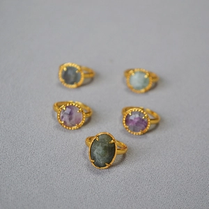 Detail of vintage brass rings with beaded edges and varied natural stone settings