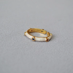 Detail of bamboo joint gold ring with white enamel and colorful cubic zirconia