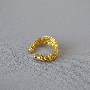 Vue détaillée d'une bague multicouche en laiton plaqué or avec texture maille tressée