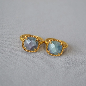 Detail of two vintage gold rings with square faceted gradient fluorite gemstones