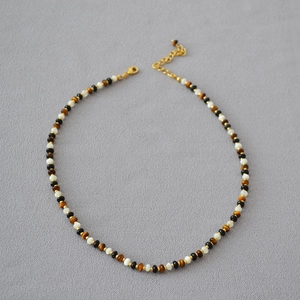 Elegant beaded necklace with tiger eye, onyx, and mother of pearl beads with gold clasp