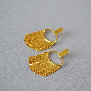 Vue détaillée des boucles d'oreilles longues dorées à pampilles et chaînes élégantes
