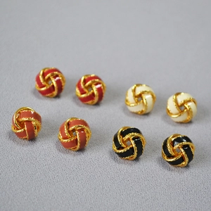 Détail de boucles d'oreilles nœuds en émail avec bordure dorée torsadée en quatre coloris
