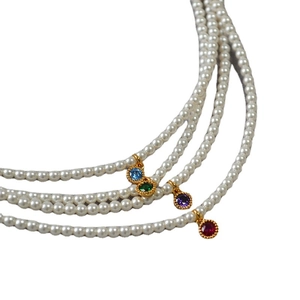 Three-layer pearl necklace with colorful gemstone pendants in a minimalist French style
