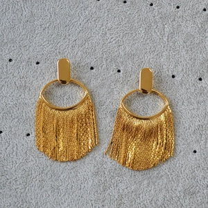 Détail de boucles d'oreilles frangées plaquées or avec glands à chaîne et clous ovales