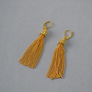 Elegant gold-plated brass tassel earrings with lever-back closure on grey textured fabric