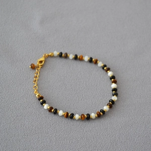 Elegant beaded necklace with tiger eye, mother of pearl, and onyx in a vintage design