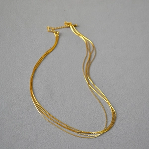 Detail of multilayer golden snake chains with lobster clasp and adjustable link chain