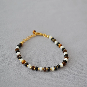 Detailed shot of beaded necklace with tiger eye, onyx, and mother of pearl beads