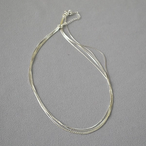 Detailed view of silver multi-layered fine chain necklace with adjustable extender link