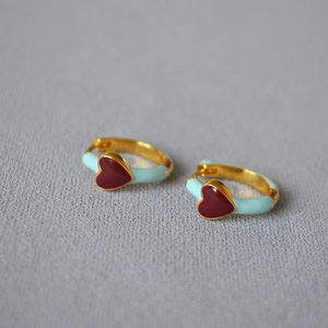 Macro shot of French vintage enamel hoop earrings with light blue coating and red heart