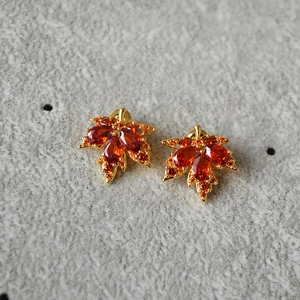 Detailansicht der Ahornblatt-Ohrringe mit orangefarbenen Zirkonia und Goldbeschichtung