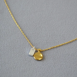 Minimalist two-tone necklace with gold round pendant and silver rectangle charm on fine chain