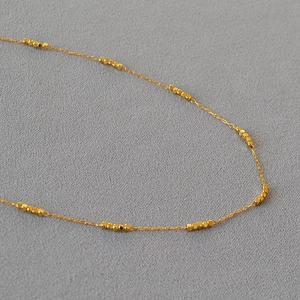 Minimalist gold plated brass choker necklace featuring shiny faceted square bead details