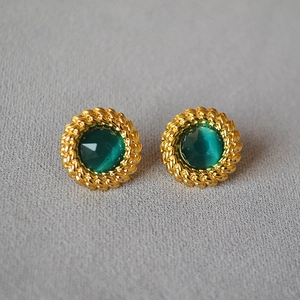 Boucles d'oreilles vintage dorées avec pierre précieuse vert émeraude sur tissu