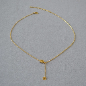 Détail du collier plaqué or avec pendentif cylindrique ajouré et chaîne délicate