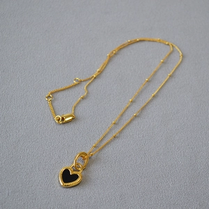 Collier chic à perles dorées avec pendentif coeur noir et bordure perlée raffinée