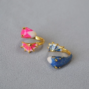 Macro detail of adjustable enamel dinosaur rings with colorful glitter finish in gold