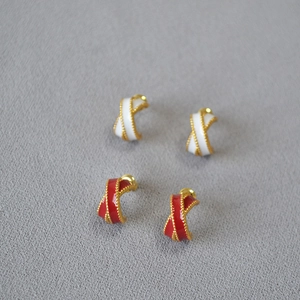 Detail of red and white enamel C-shaped hoop earrings with gold beaded edges