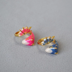Macro detail of gold-plated fish rings with pink and blue glitter enamel finish