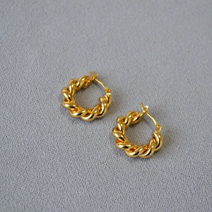 Boucles d'oreilles créoles torsadées dorées avec motif tressé et finition métallique polie