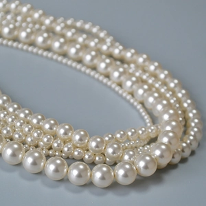 Gros plan détaillé d'un collier de perles artificielles multicouches au design élégant crème