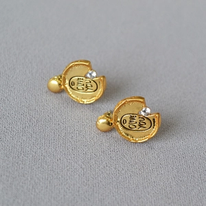Detail of gold hammer-textured earrings featuring Olive You text and a zircon stone