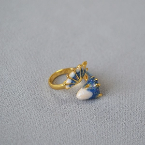Macro detail of dinosaur ring with blue starry enamel and golden adjustable band