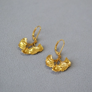 Detail of layered ginkgo leaf earrings with golden finish and realistic vein texture