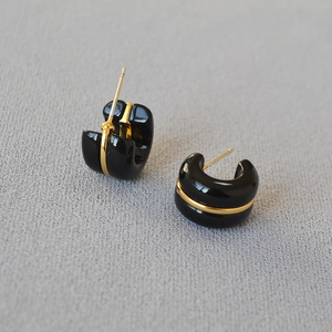 Minimalist C-shaped hoop earrings in black enamel with sleek gold wire detailing