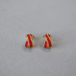 Macro shot of French style red enamel cross stud earrings with golden milgrain bead edges