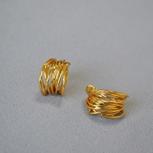 Detailed view of gold multi-layer tangled rings with high-polish metallic texture
